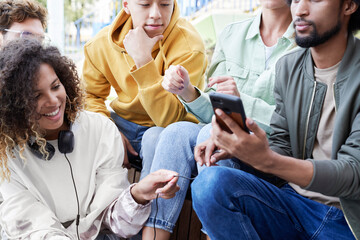 Group of best friends sitting together with mobile phone