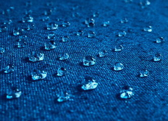 Water drops on blue waterproof fabric.