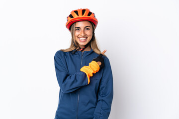 Young hispanic cyclist woman isolated on white background pointing to the side to present a product