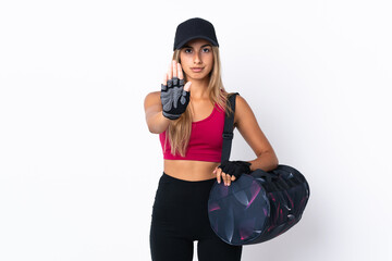 Young sport woman with sport bag over isolated white background making stop gesture