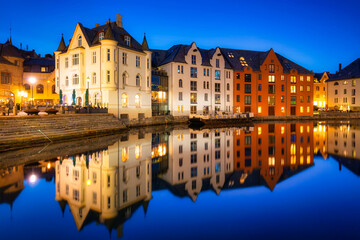 Fototapeta na wymiar Architecture of Alesund city reflected in the water at night, Norway