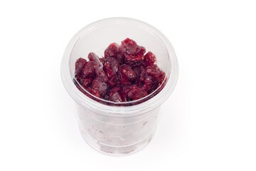 Dried cranberries in closed plastic food container on white background