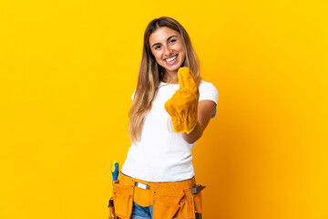 Young hispanic electrician woman over isolated yellow wall making money gesture