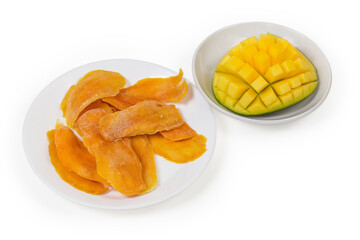 Dried mango slices on dish against a fresh cut mango