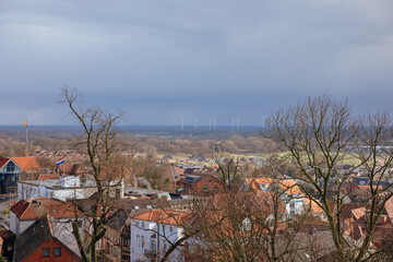 Top view of a German city with white wind turbines in the distance. Energy transition in Europe....