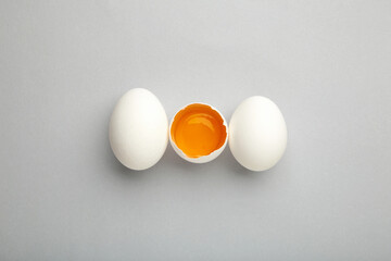 White eggs and egg yolk on the grey background. Easter concept
