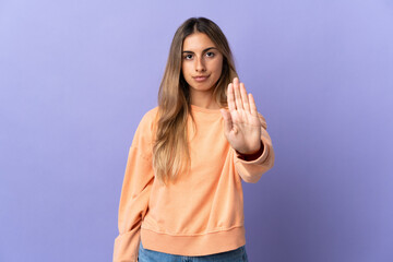 Fototapeta na wymiar Young hispanic woman over isolated purple background making stop gesture