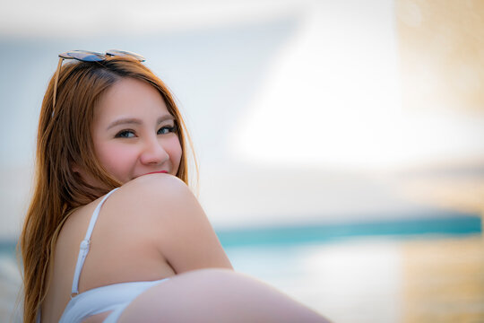 Young beauty woman relaxing  beside the swimming pool .