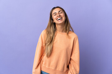 Young hispanic woman over isolated purple background laughing