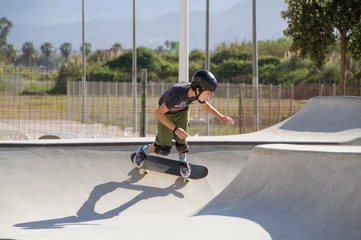 Afwasbaar fotobehang Teenage boy in skateboard park against blue sky © Jose Prieto