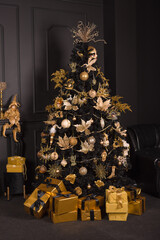 New Year, Christmas tree in black with gold decorations and gifts. Stylish dark gold interior.