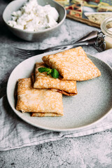 crepes with homemade cottage cheese on a gray plate