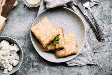 crepes with homemade cottage cheese on a gray plate
