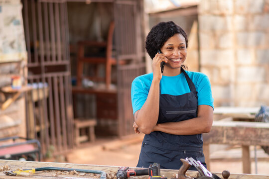 female african carpenter smiling while making a phone call
