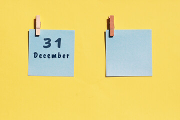 31 December. 31th day of the month, calendar date. Two blue sheets for writing on a yellow background. Top view, copy space. Winter month, day of the year concept