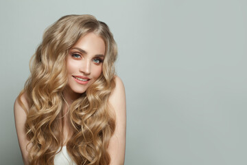 Young blonde woman smiling on white background