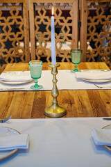 Set table with burning candle in a kosher Jewish restaurant in Israel