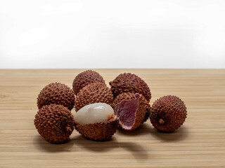 Several lychee fruits, one with open peel
