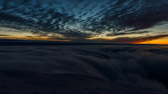 Day to night time lapse video. Beautiful sunset view over clouds in winter Ukrainian Carpathian mounains. Winter season, snowy landscape.