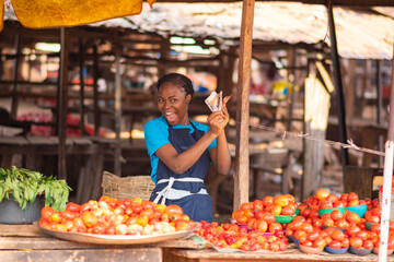 african market woman holding money excitedly and happy like she won a prize