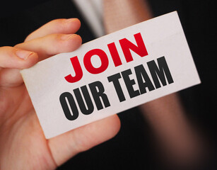 Businessman holds a card with the text Join Our Team. Business concept