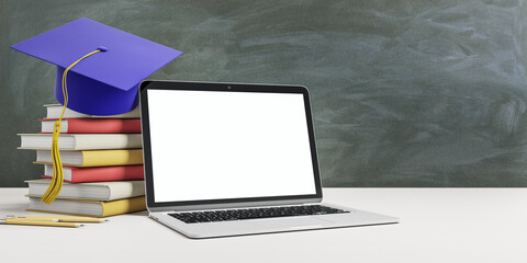 Online education concept with stack of books, blue graduate cap and blank white laptop screen on wooden table at blackboard background. Mockup