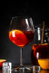 Refreshing red wine sangria or punch with fresh fruits in glasses and pincher on black background