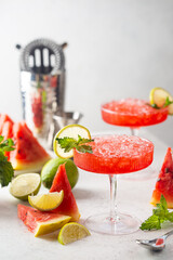 Watermelon frozen cocktail margarita with fresh watermelon, lime and mint on white background