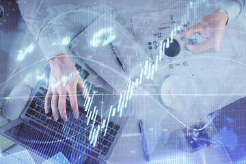 Multi exposure of man's hands typing over computer keyboard and forex graph hologram drawing. Top view. Financial markets concept.