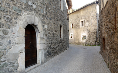 the alleys with houses and stone floors of the alpine village in the center of Bormio.
