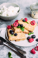 Crepes with homemade cottage cheese, raspberries a gray plate