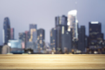 Blank wooden tabletop with beautiful blurry skyline at night on background, mockup