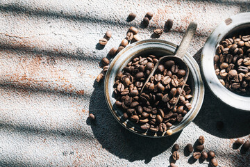 Coffee beans in ceramic plates on a gray background. Sunlight.