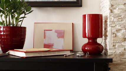 Komódka mebel w salonie z ramką czerwoną, karteczką kolorową i lampką szklaną bordową - obrazy, fototapety, plakaty