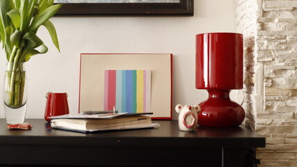 Fototapeta Komódka mebel w salonie z ramką czerwoną, karteczką kolorową i lampką szklaną bordową obraz