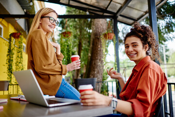 Laughing female friends having coffee break