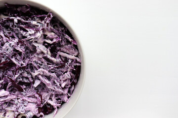 Obraz na płótnie Canvas Easy homecooked creamy coleslaw from red cabbage in a bowl on white table background. Top view, copy space. Fresh vegetable salad with mayonnaise dressing. Flat lay food. Healthy eating concept 
