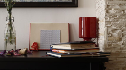 Komódka mebel w salonie z ramką czerwoną, karteczką kolorową i lampką szklaną bordową - obrazy, fototapety, plakaty