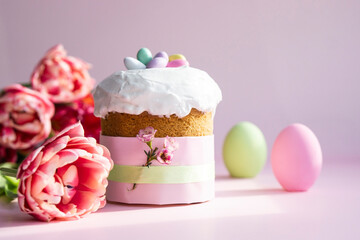 Easter cake and colorful eggs  and flowers on  pink pastel Easter . background .