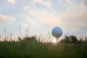 golf ball on tee in a beautiful golf course with morning sunshine