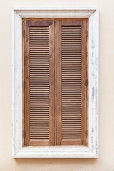 Fototapeta premium European antique brown wooden shutters window and white cement wall