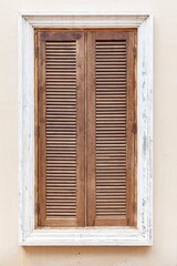 European antique brown wooden shutters window and white cement wall