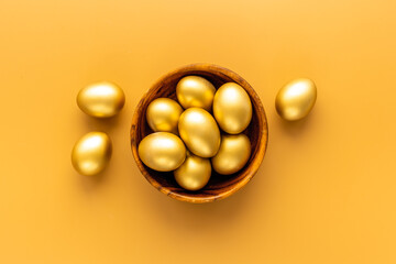 Golden Easter eggs in wooden bowl. Wealth and good luck concept.