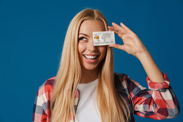 Blonde happy white woman smiling while making fun with credit card