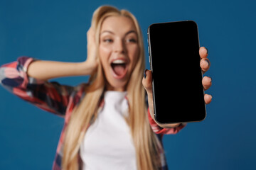 Blonde excited white woman exclaiming while showing mobile phone