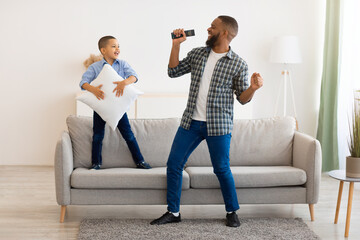 Happy Black Father And Son Having Fun Singing At Home
