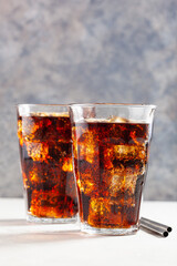 glass of cold cola soft drink with ice on concrete background