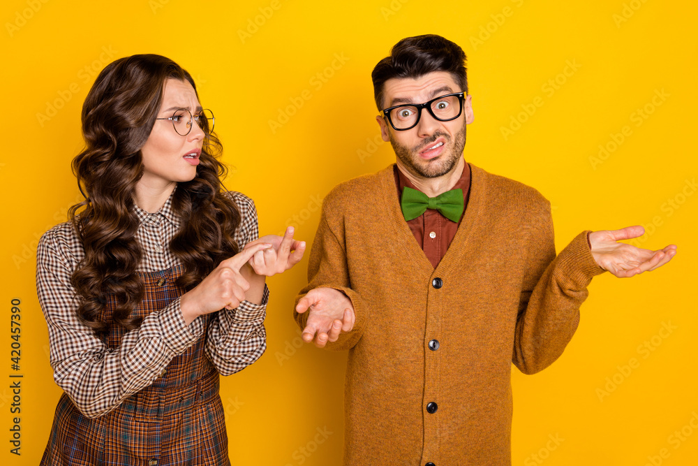 Sticker Portrait of attractive irritated couple nervous girl saying pretense to puzzled guy isolated over bright yellow color background