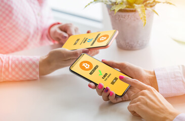 Friends transferring bitcoins on their phones