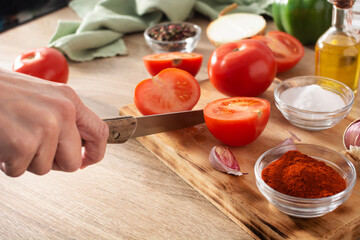 woman cutting fresh tomatoes to make sauce